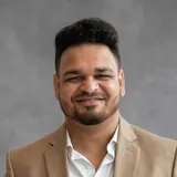 Mukul Agnihotri, Wise Bucks mentor, in a beige blazer against a grey backdrop